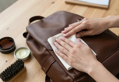 Application d'une crème nourrissante au chiffon doux sur un sac à dos en cuir marron