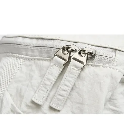 Close-up of the two zip pulls on the off-white backpack