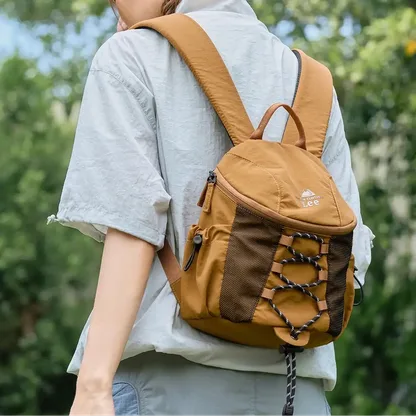 Woman seen from behind outdoors, wearing the brown backpack