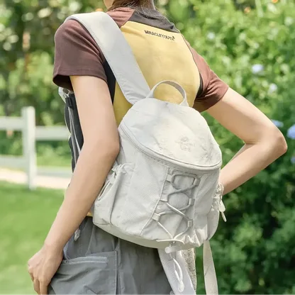 Woman seen from behind outdoors, wearing the off-white backpack