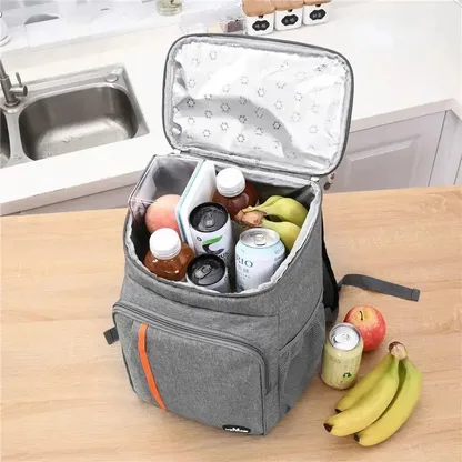 Grey cooler backpack open on a kitchen worktop, packed with drinks and fruit