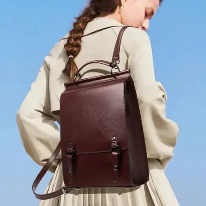 Woman wearing the vintage leather backpack on her back against a blue sky