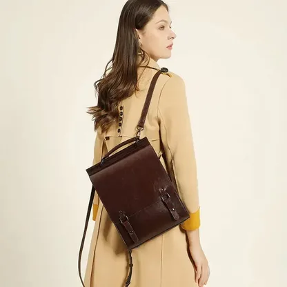 Woman in a trench coat wearing the vintage leather backpack on one shoulder