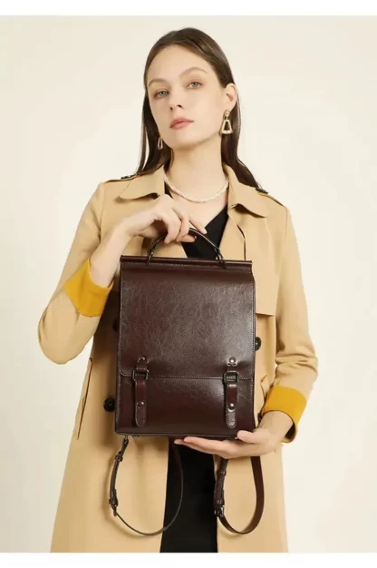 Woman holding the vintage leather backpack in front of her