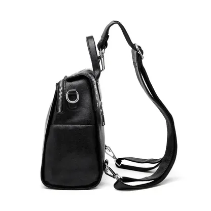 Black riveted leather backpack seen from the side, with its straps