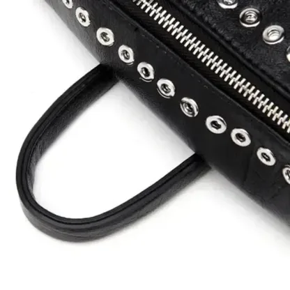 Close-up of the metal rivets and the top handle of the black leather backpack