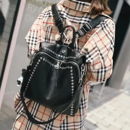 Woman wearing the black riveted leather backpack on her back
