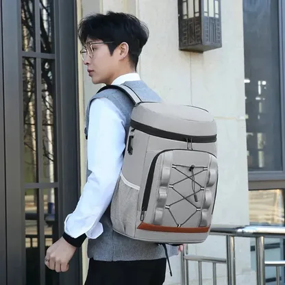 Man wearing the light grey insulated backpack in the street