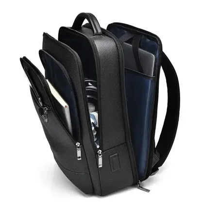 Open compartments of the faux leather backpack with a laptop inside
