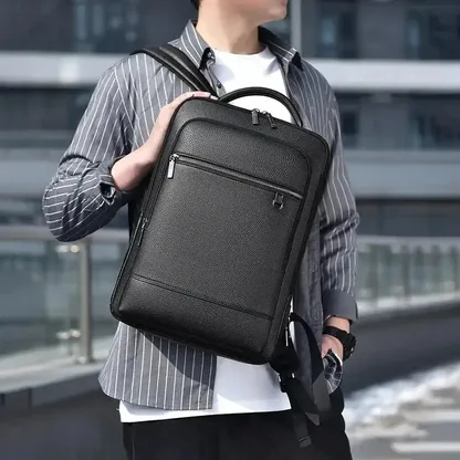 Man holding the black faux leather laptop backpack