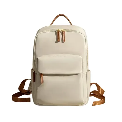 Beige backpack with a cognac top handle, cognac straps and gold zips, front view