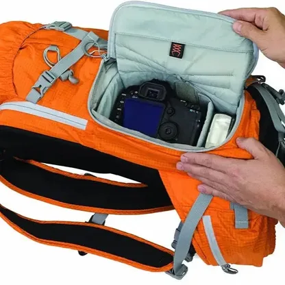Camera and accessories in the padded side compartment of the orange backpack